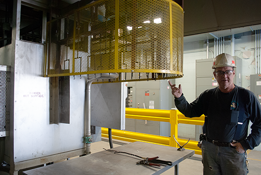 Rich Rusnak standing next to safety guards in production plant