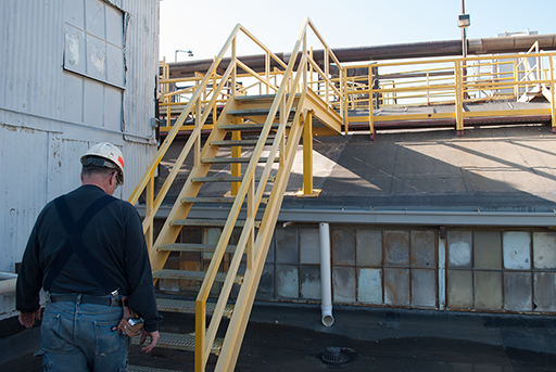 Yellow safety rails and stairs connecting different level of facility roof