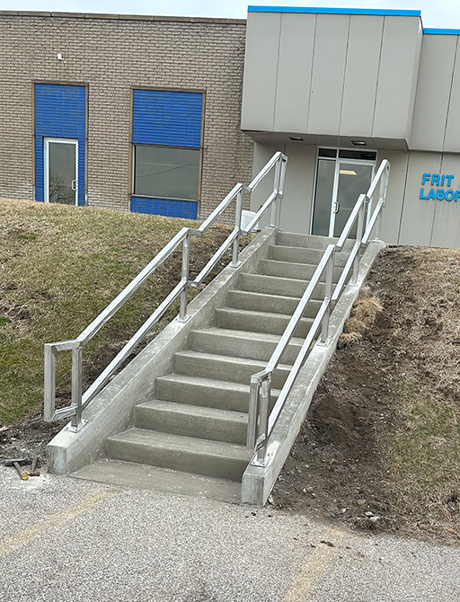 Stainless steel exterior railing for stairs with 12 cement steps (view from bottom)