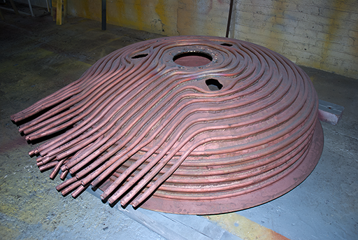 copper pot (upside down to show tubing that leads out from the pot to other connections)