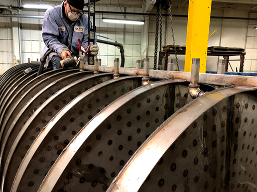 Clint welding water valves onto vibratory feeder