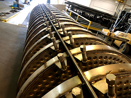 Long view of the rows of water valves down the side of a vibratory feeder