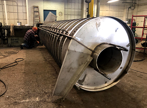 one end of vibratory feeder where materials enter or exit