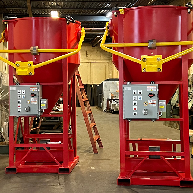 Two electric-based materials mixers on fabricated bases and painted red