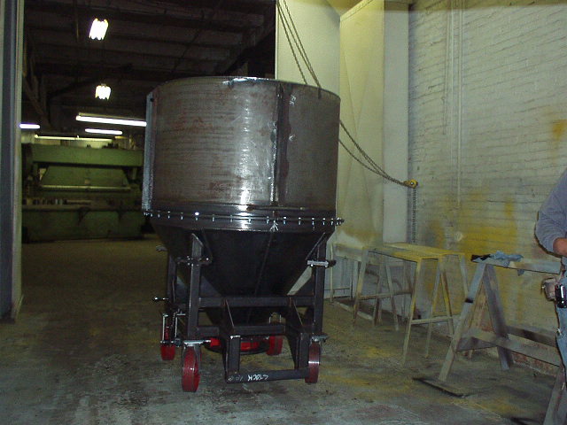 Hopper on a metal frame base with red wheels