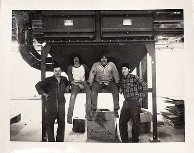 Thomas J. with 3 employees from the early years in front of a dust collector